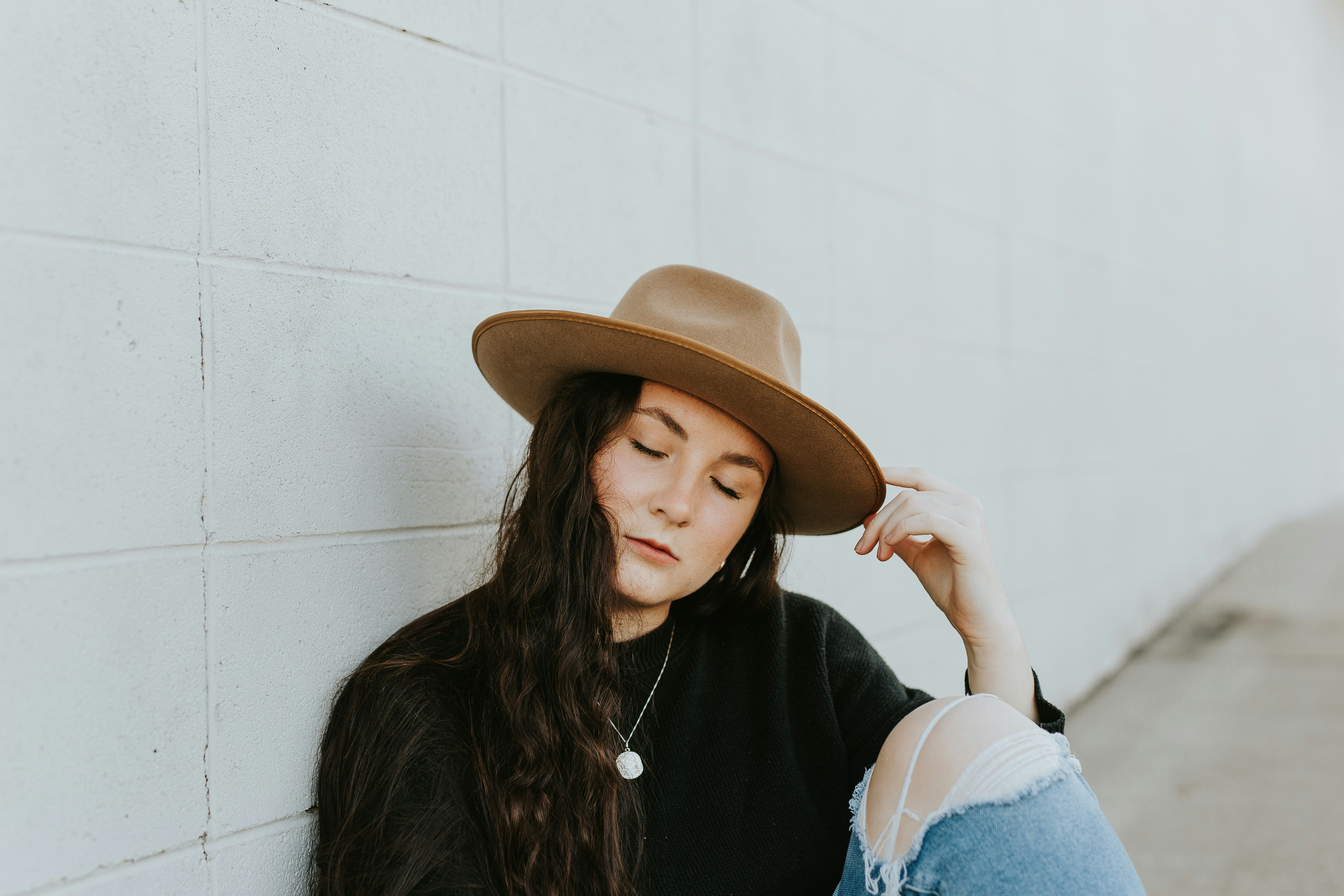 woman in black long sleeve shirt wearing brown hat